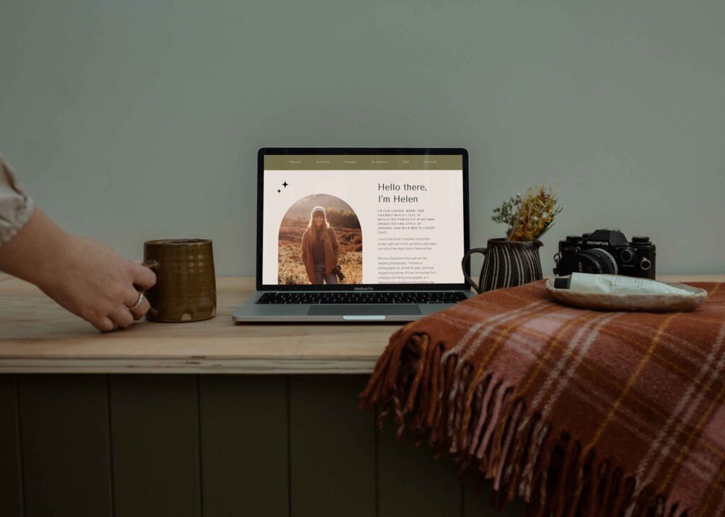 A laptop with an image of a photographer, and a cup of coffee. This is representing how photographers can spring clean their photography business.