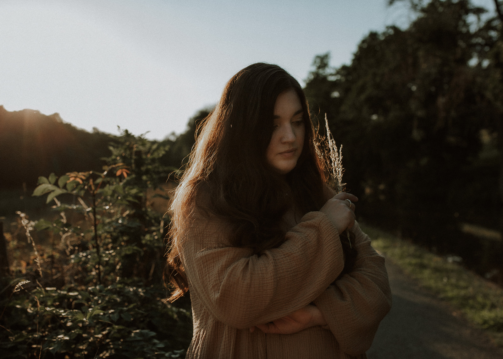 Image of a woman holding dried grasses thinking about photographer burnout and three rituals to help you feel less overwhelmed