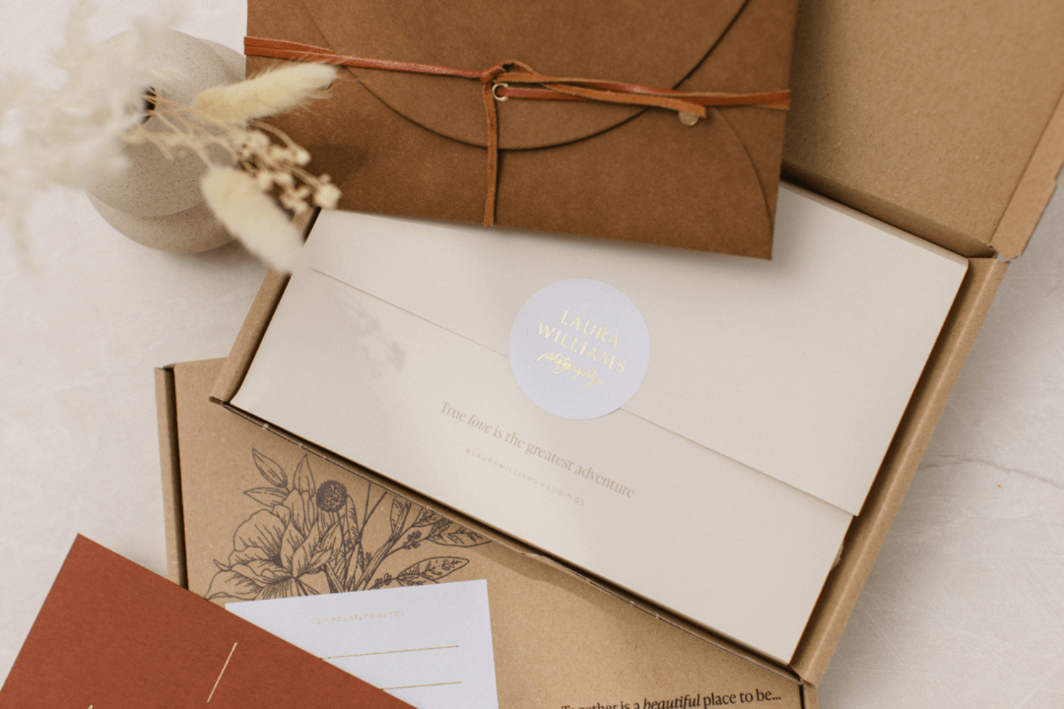 A Kraft shipping box filled with a notecard and a print pouch for a final delivery packaging as a photographer