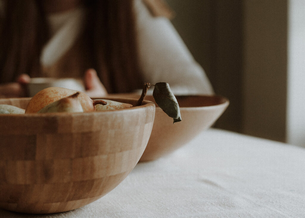 A wooden bowl with a pear inside - representing ways to celebrate abundance in your business